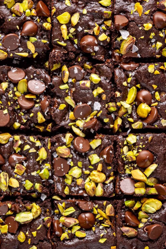 close up of fresh brownies with pistachios and chocolate chips cut into squares