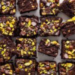 Gluten-free fudgy pistachio brownies styled with chopped chocolate and pistachios