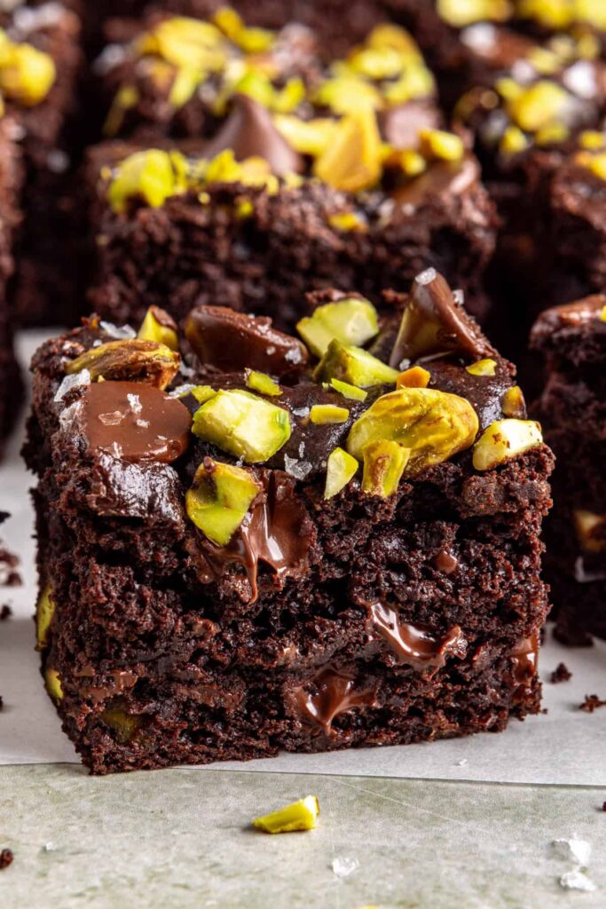 Side view of pistachio brownie square with chocolate chips and pistachios