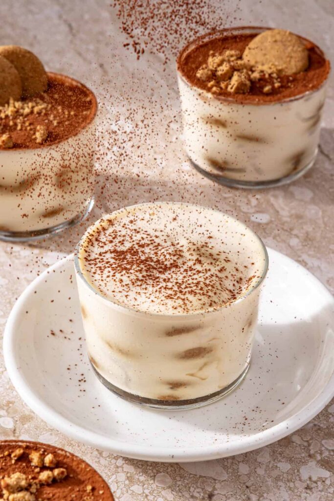 Dusting cocoa powder over high-protein tiramisu cups