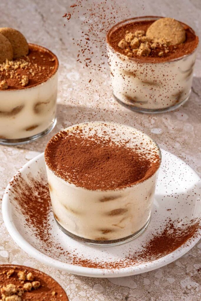Dusting cocoa powder over high-protein tiramisu cups