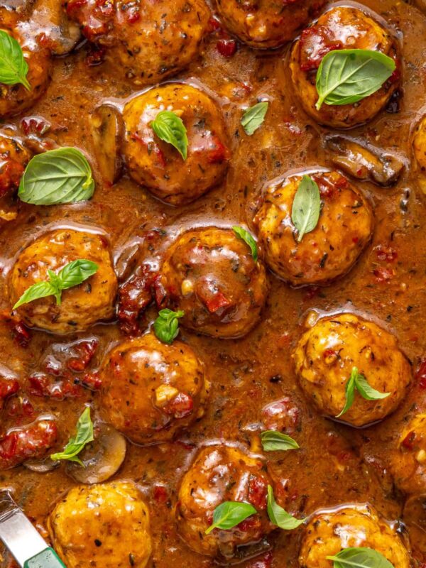 close-up of Marry me chicken meatballs with basil garnish in creamy sauce