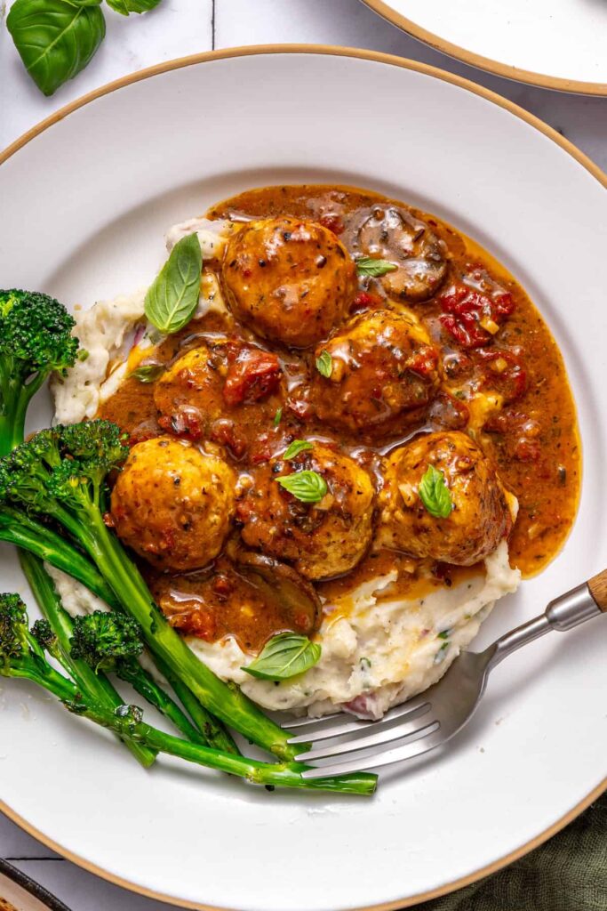 Plated marry me chicken meatballs dinner with rice and greens
