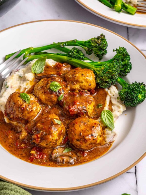 Marry me chicken meatballs served with mashed potatoes and broccolini on plate