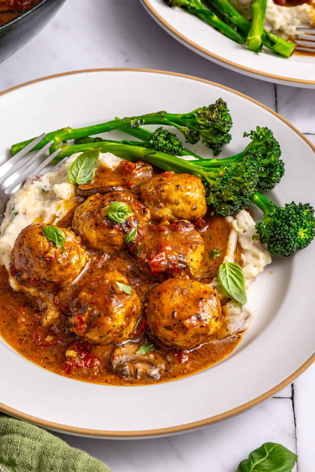 Marry me chicken meatballs served with mashed potatoes and broccolini on plate