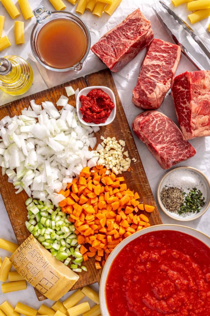 Healthy short rib ragu ingredients laid out including grass-fed beef short ribs and fresh vegetables