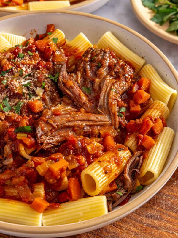 Close-up of slow cooker short rib ragu over pasta with rich tomato sauce