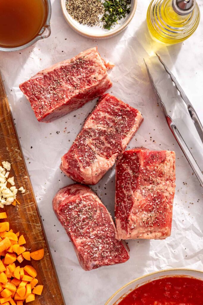 Beef short ribs seasoned with salt and pepper for short rib ragu