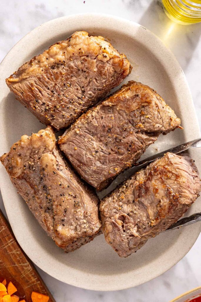 Browning beef short ribs in skillet for rich and flavorful ragu