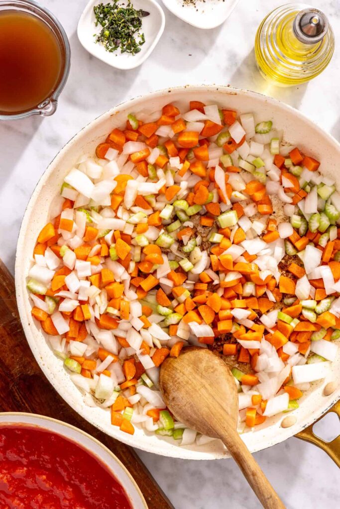 Onion carrots and celery sautéing in pan for short rib ragu base