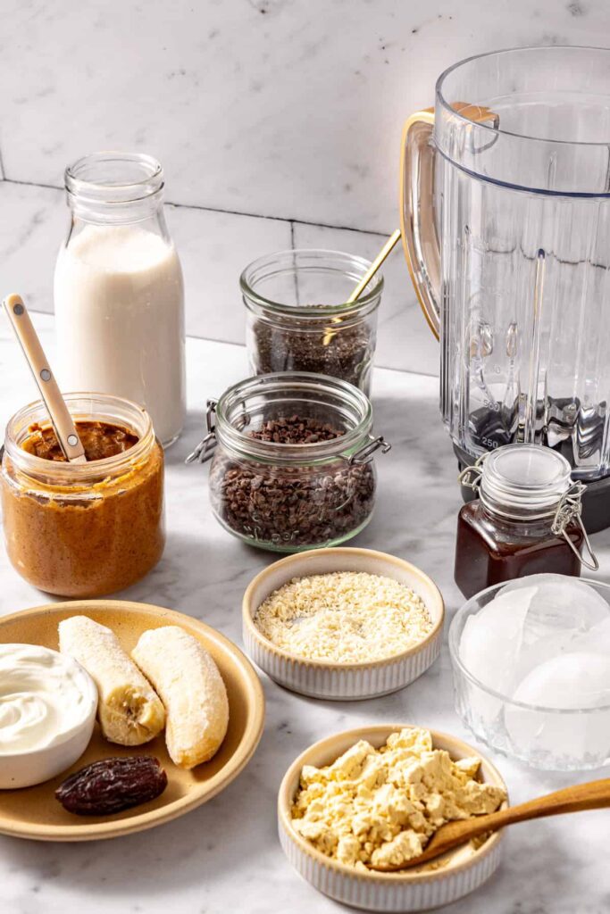 Healthy dessert smoothie ingredients including frozen banana, chia seeds, and coconut flakes