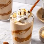 Creamy healthy dessert smoothie served in glass with toppings