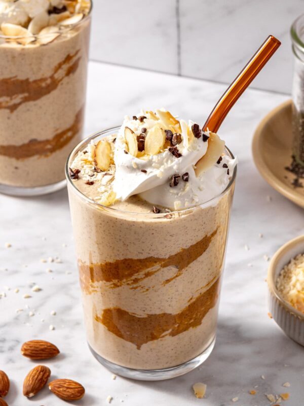 Creamy healthy dessert smoothie served in glass with toppings