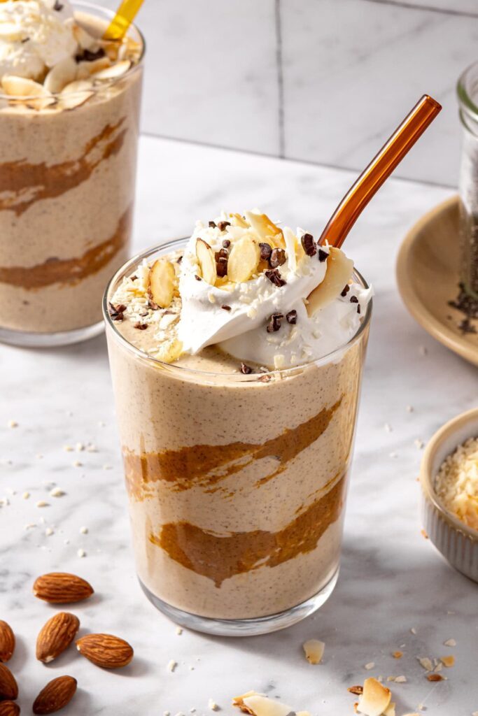 Creamy healthy dessert smoothie served in glass with toppings