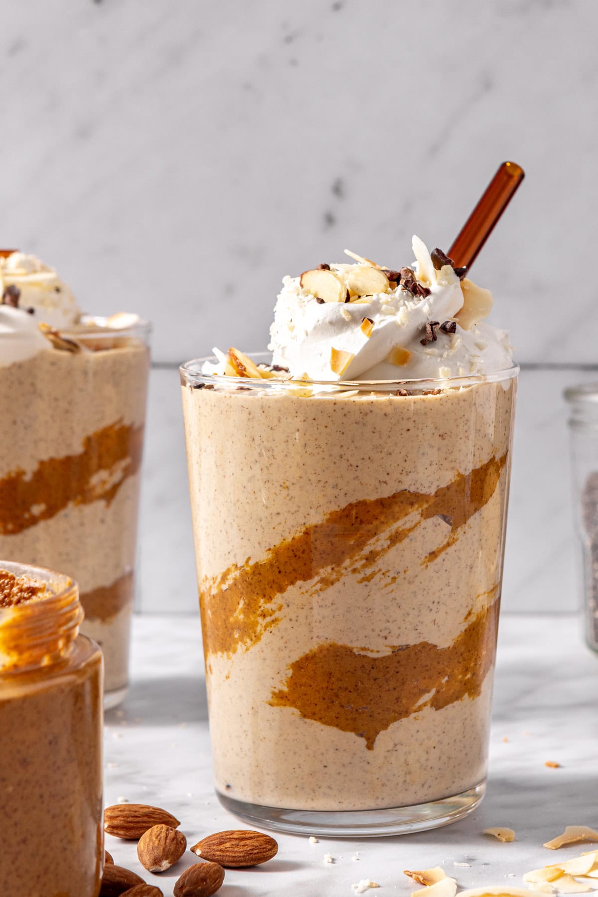 Chocolate coconut smoothie with straw and almond butter drizzle