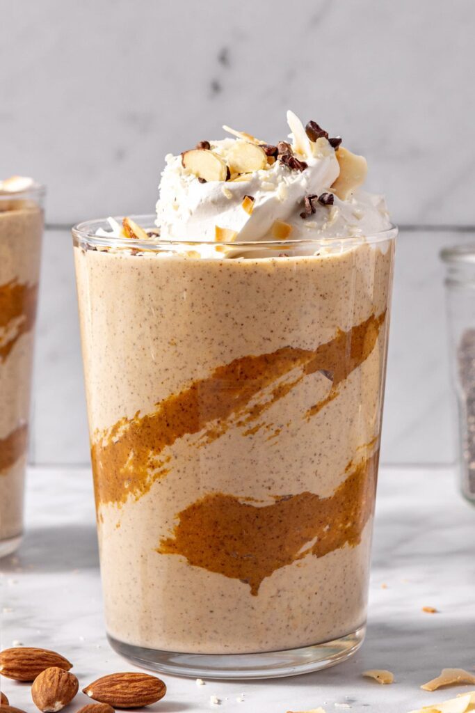 Creamy healthy dessert smoothie served in glass with toppings