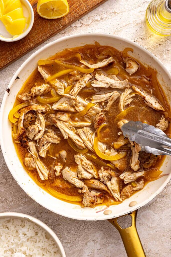 Cooking chicken thighs with broth and vegetables for rice bowls