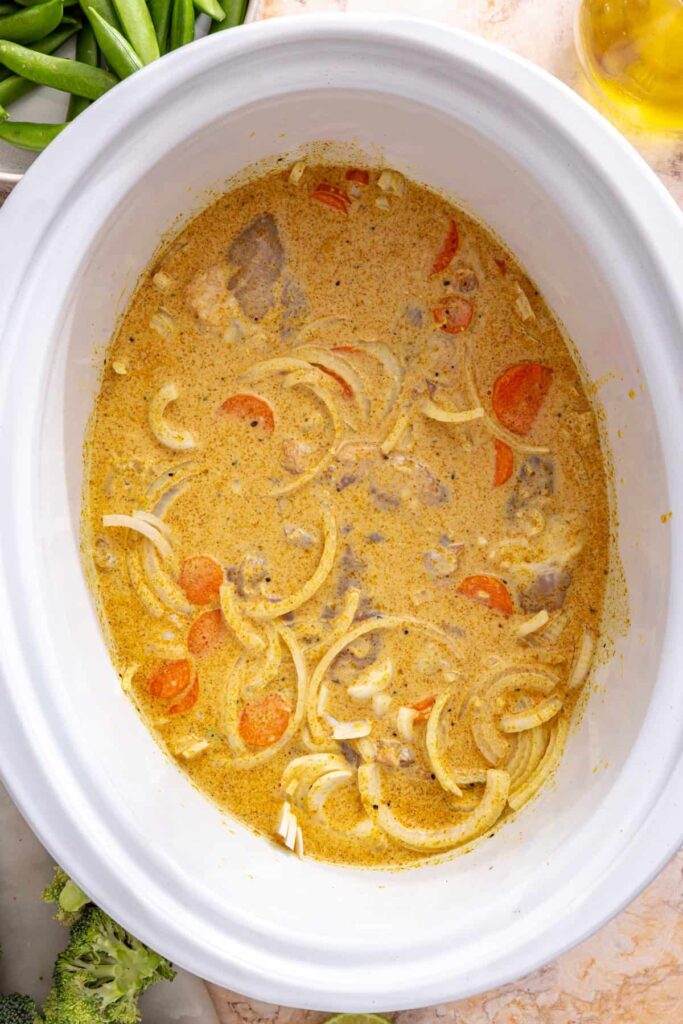 uncooked slow cooker chicken curry ingredients combined in crockpot