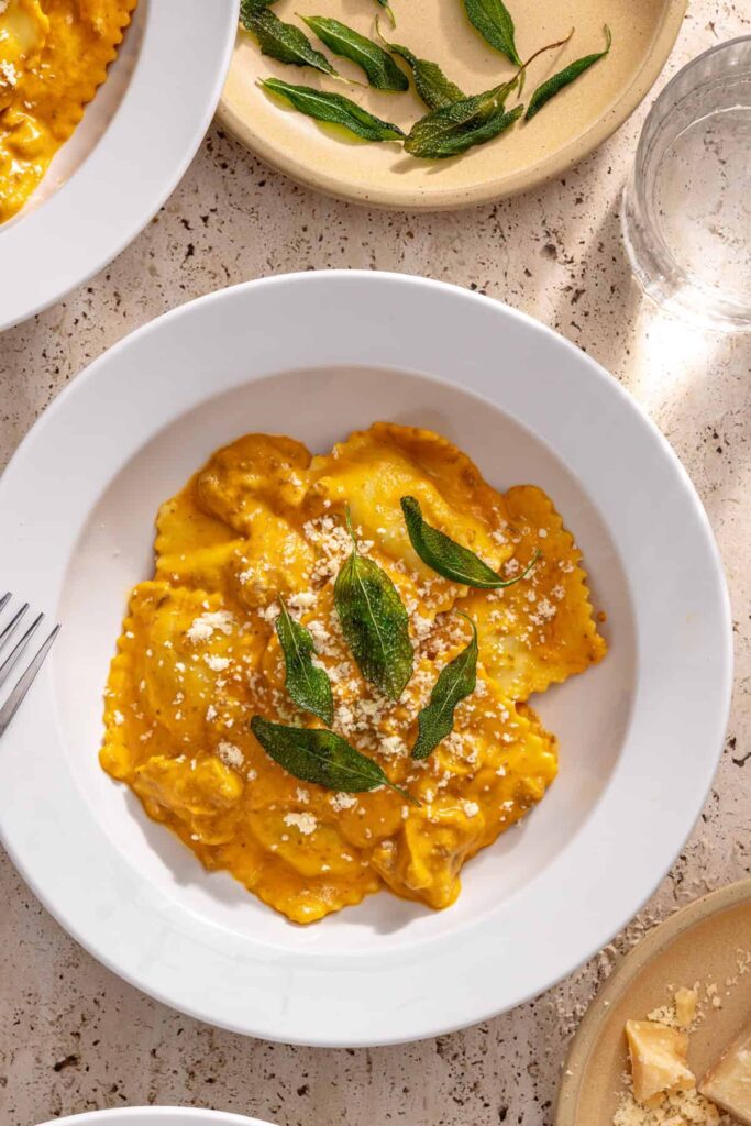 Overhead photo of creamy ravioli with hidden veggie sauce and crispy sage