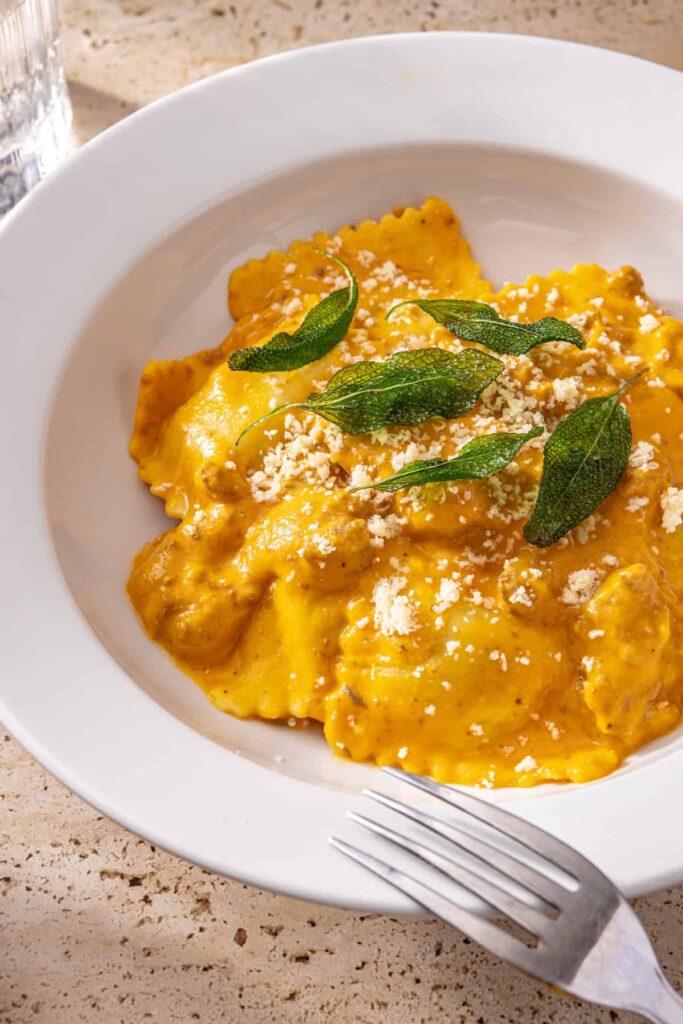 Butternut squash ravioli topped with parmesan and fried sage