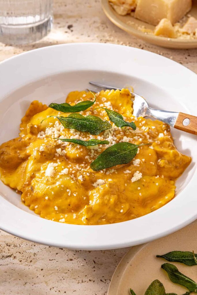 hidden veggie butternut squash ravioli served in a white bowl with a fork