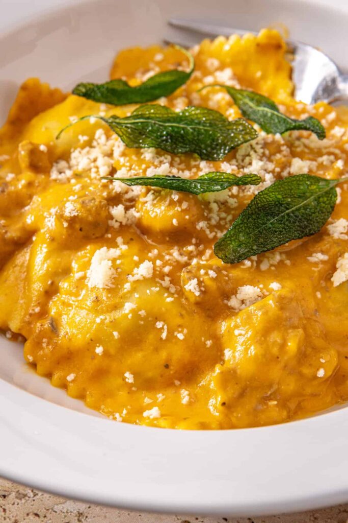 Detailed view of ravioli coated in creamy butternut squash sauce