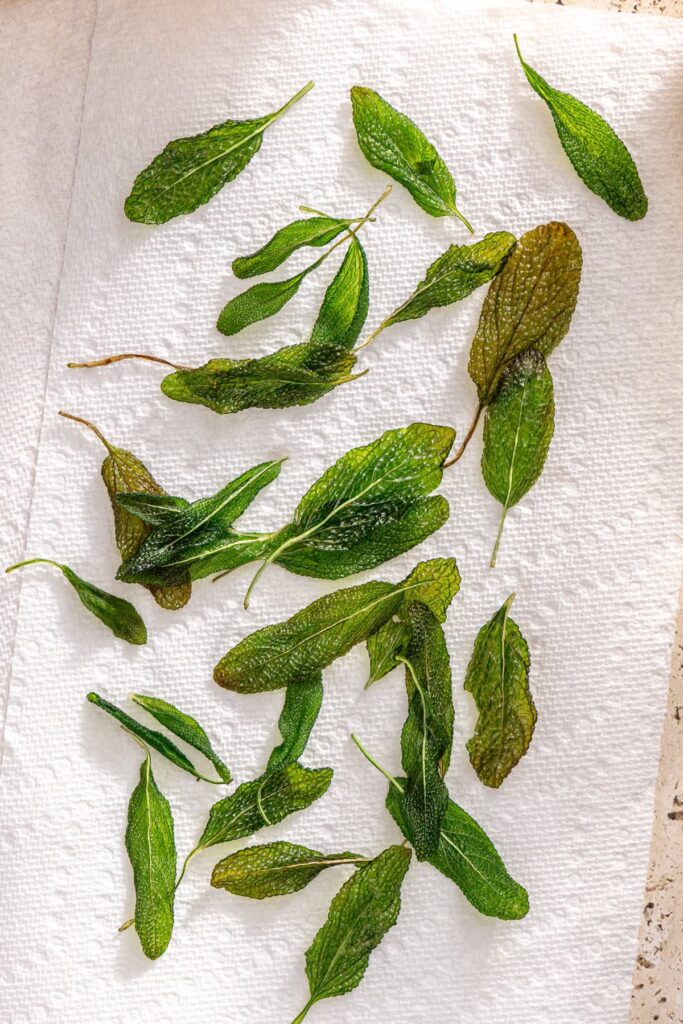 Crispy fried sage draining on paper towel