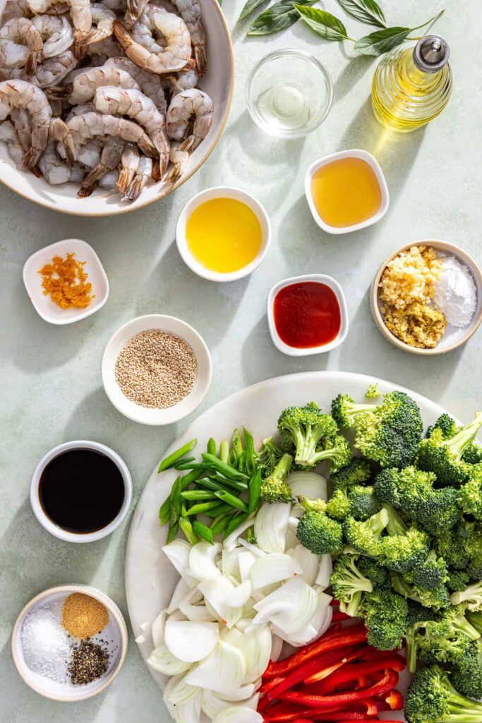 Ingredients laid out for easy shrimp stir fry with fresh vegetables, shrimp, and homemade sauce