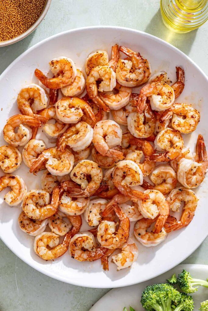 Cooked shrimp resting on plate before adding back to stir fry