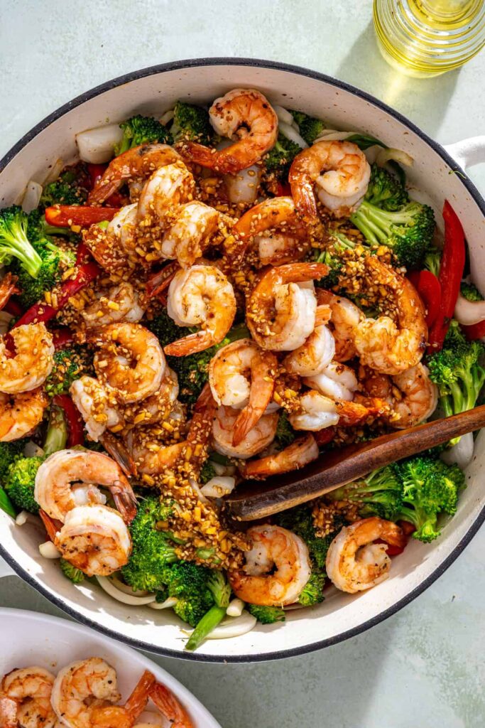 Shrimp and vegetables cooking together in skillet with stir fry sauce