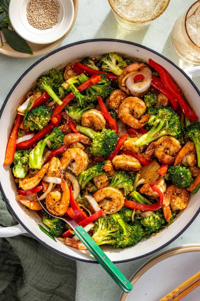 Stirring shrimp and veggies in thickened sauce for shrimp stir fry