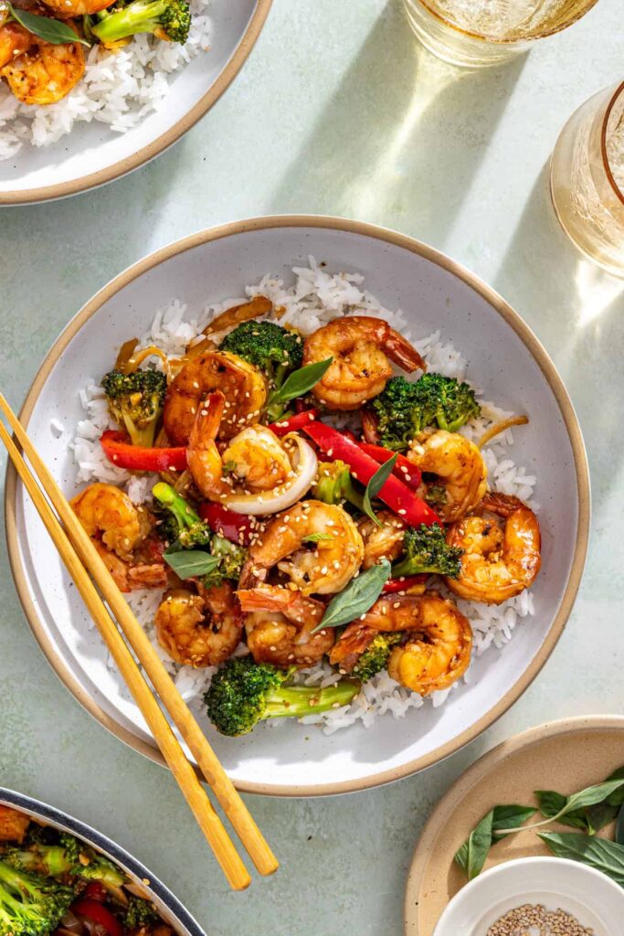 Styled shrimp stir fry scene with chopsticks, and simple table setting