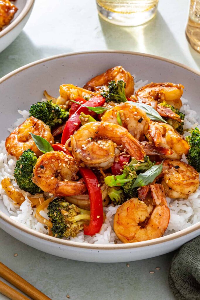 close-up of shrimp and veggie stir fry in a bowl with white rice