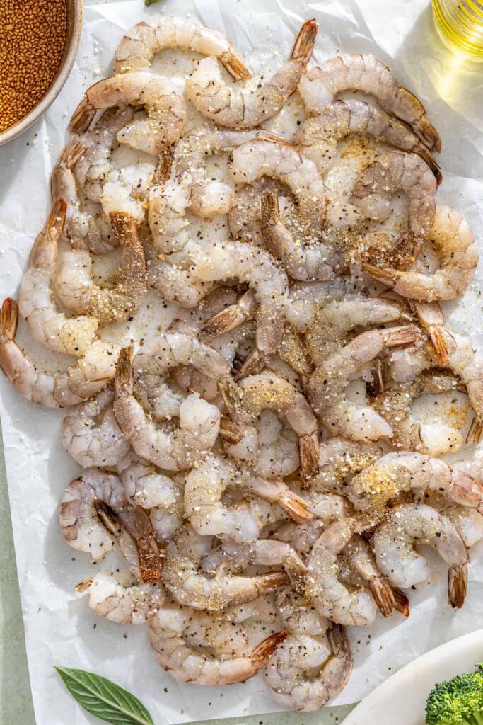 Raw shrimp seasoned with salt, garlic powder, and pepper for stir fry