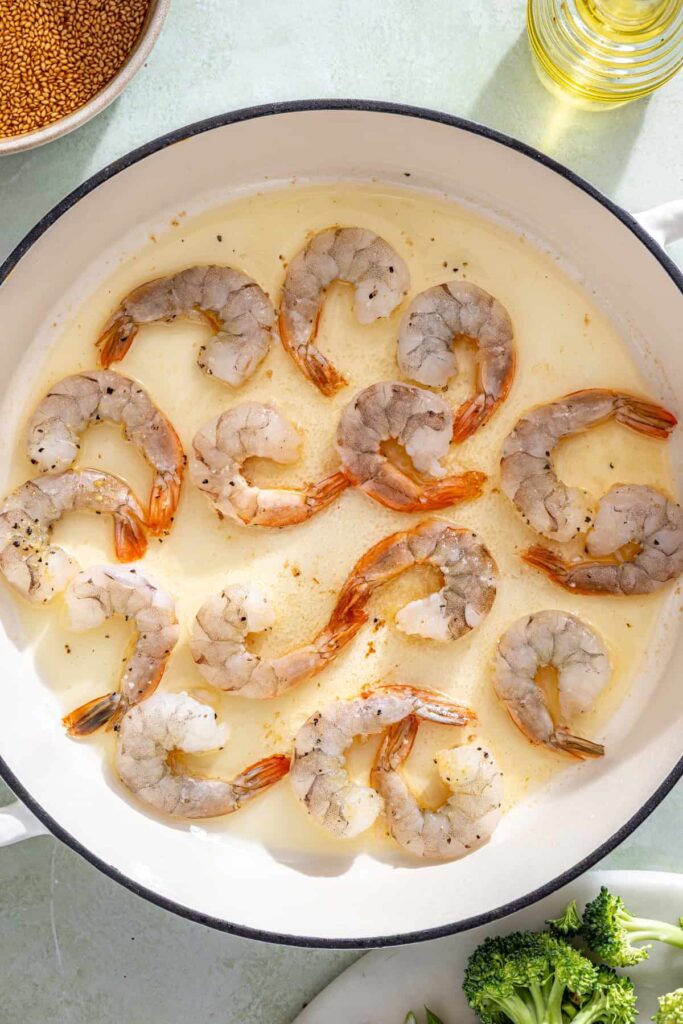 Shrimp cooking in skillet until pink and lightly golden for stir fry