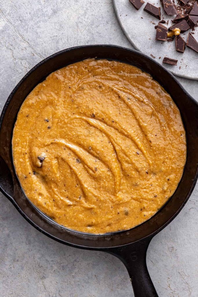 Chocolate chip cookie skillet dough pressed into cast iron skillet