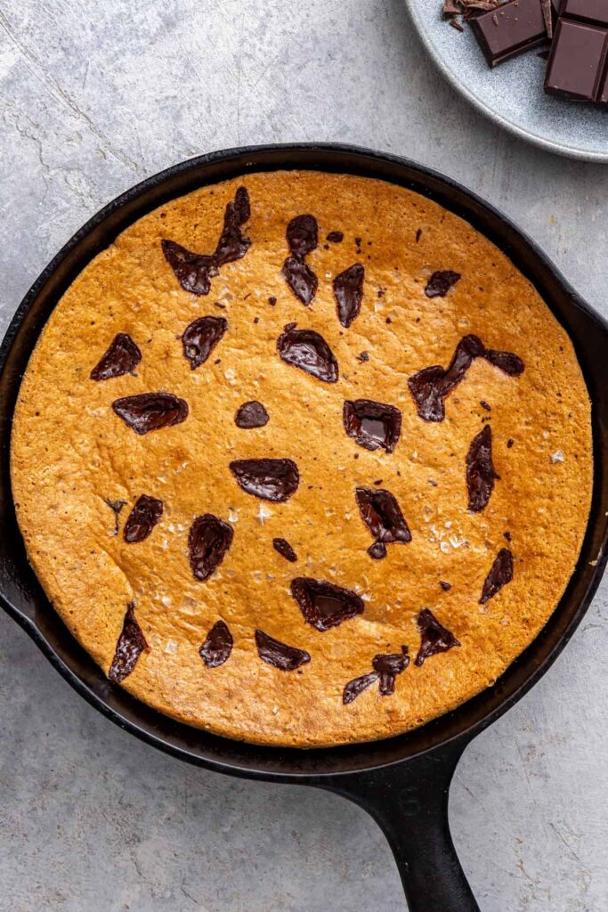 Freshly baked chocolate chip cookie skillet in cast iron pan