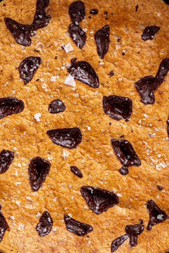 zoomed in shot of a warm and gooey healthy chocolate chip skillet cookie, fresh out of the oven