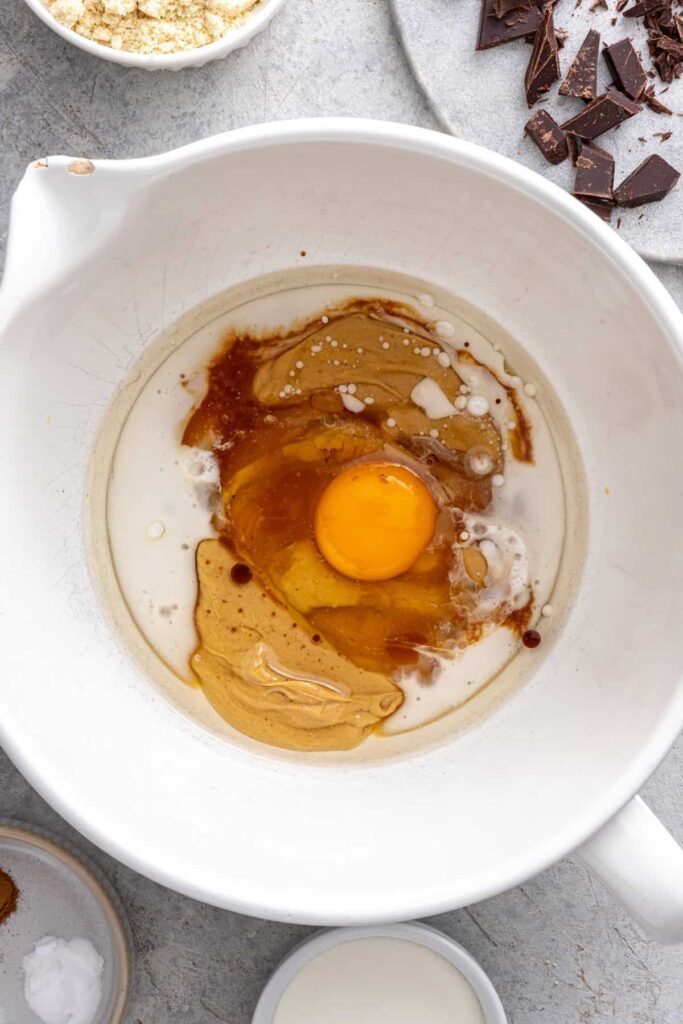 Cashew butter, egg, maple syrup, and coconut oil in a mixing bowl for gluten-free cookie skillet