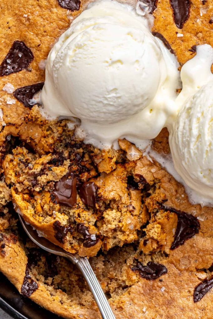 overhead close-up shot of Chocolate chip cookie skillet topped with dairy-free vanilla ice cream