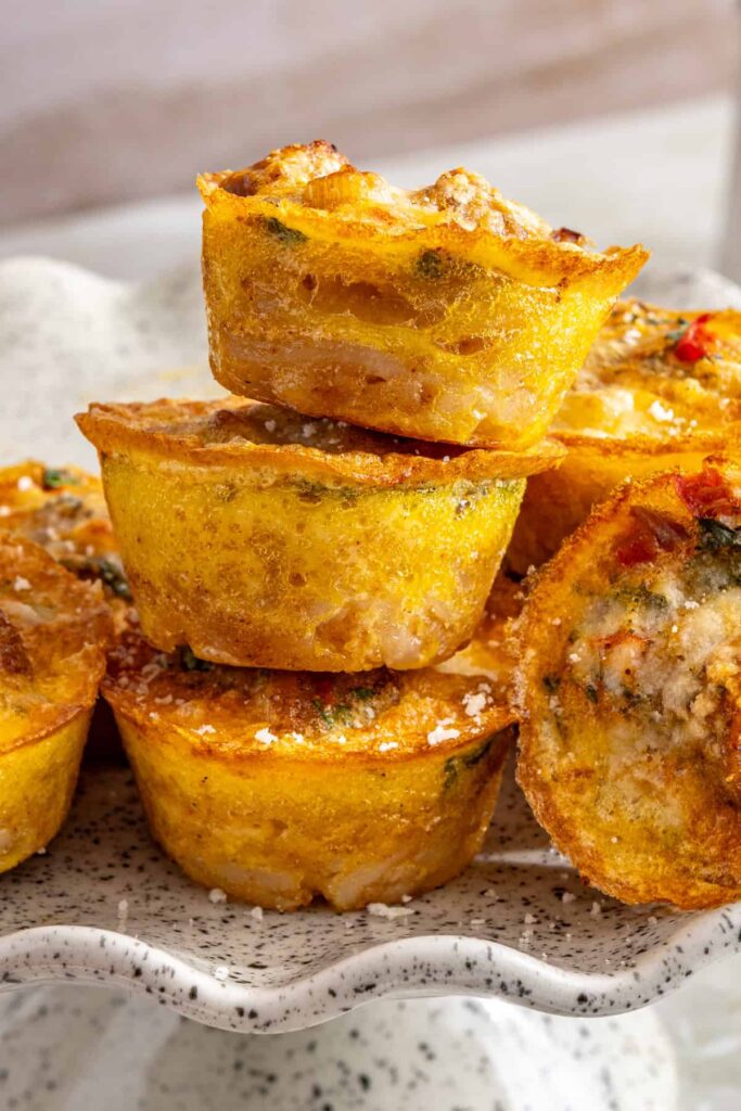 Close-up of three gluten-free quiche cups stacked on top of each other showing crispy edges