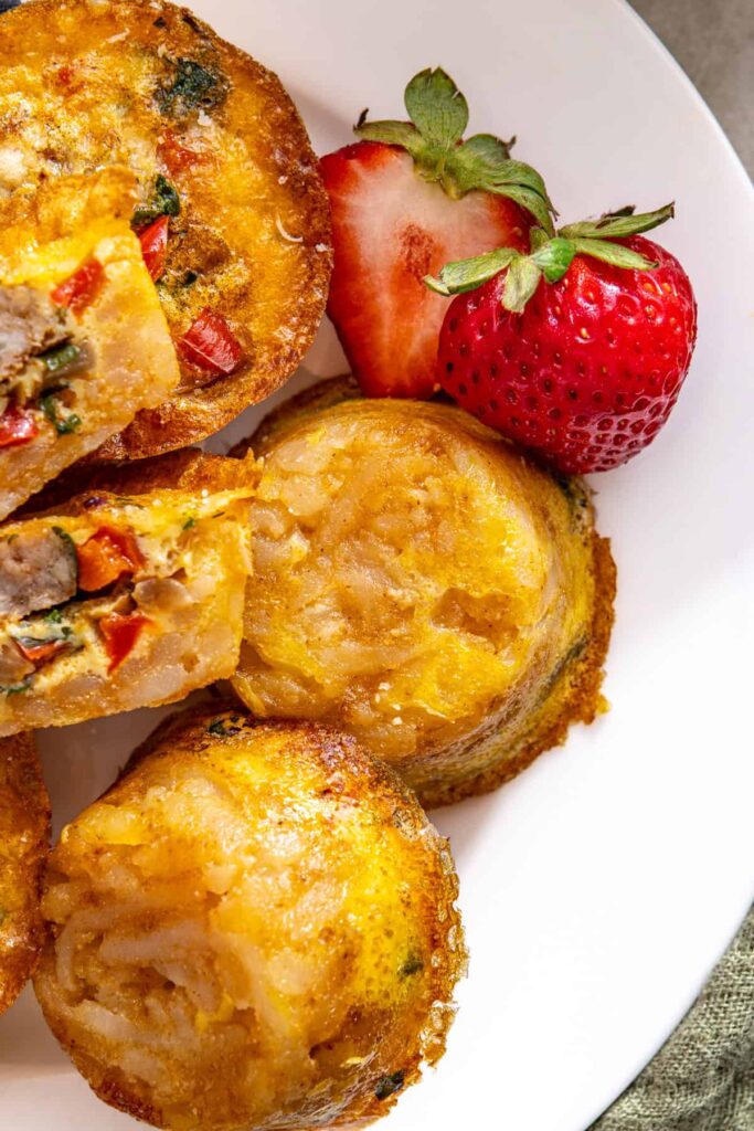Plated mini quiche cups with decorative strawberry on edge of plate