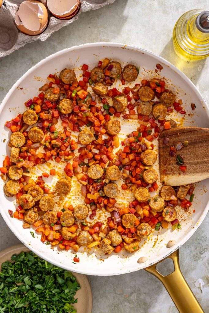 Sautéing vegetables and chicken sausage filling for gluten-free quiche cups in skillet