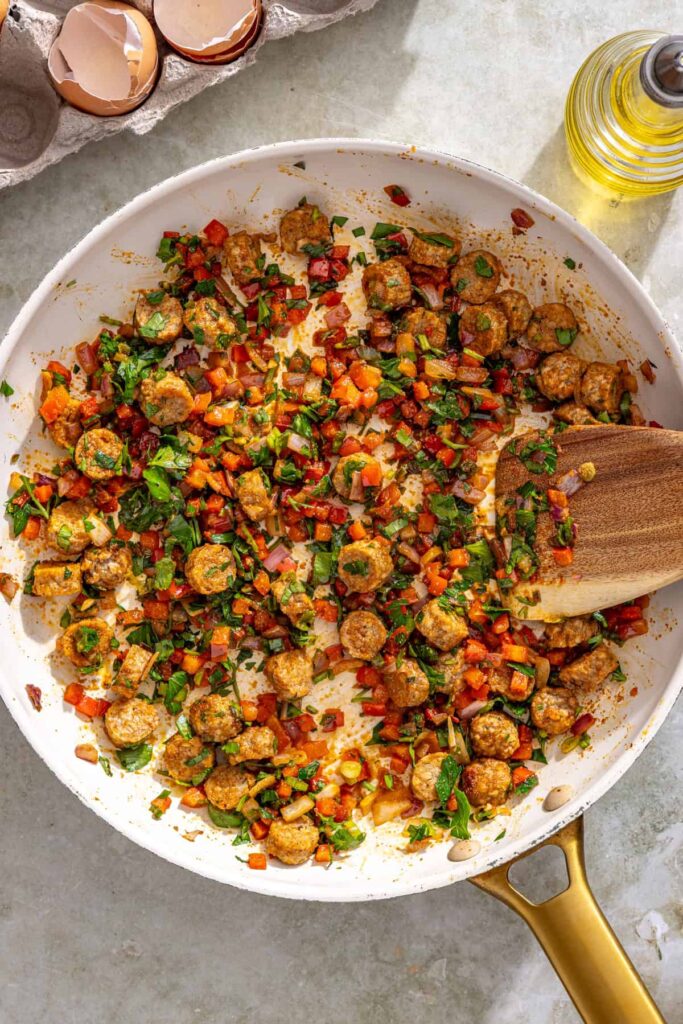 Cooking bell pepper, onion, scallions, and sausage mixture for mini gluten-free quiche cups