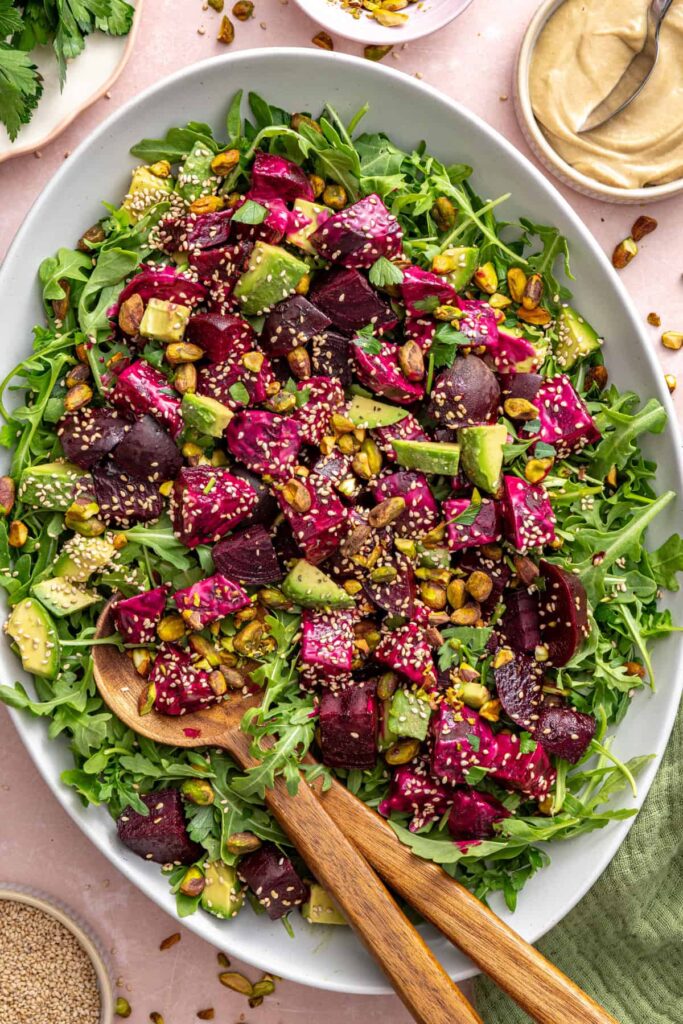 Overhead view of roasted beet salad served on a platter with a serving spoon