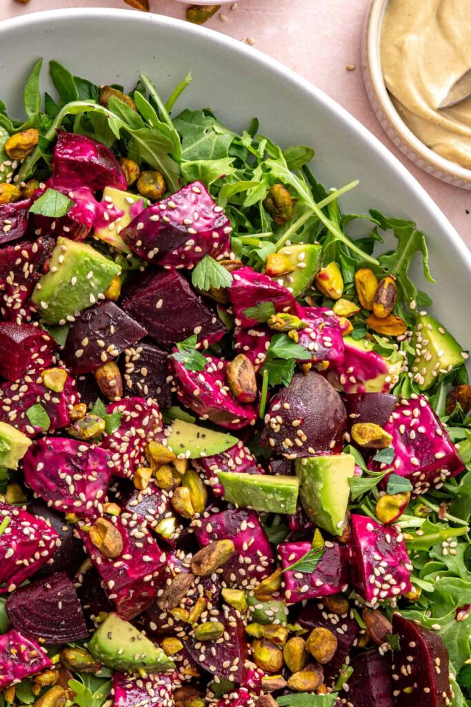 Overhead shot of beet salad with goat cheese and arugula on a serving platter