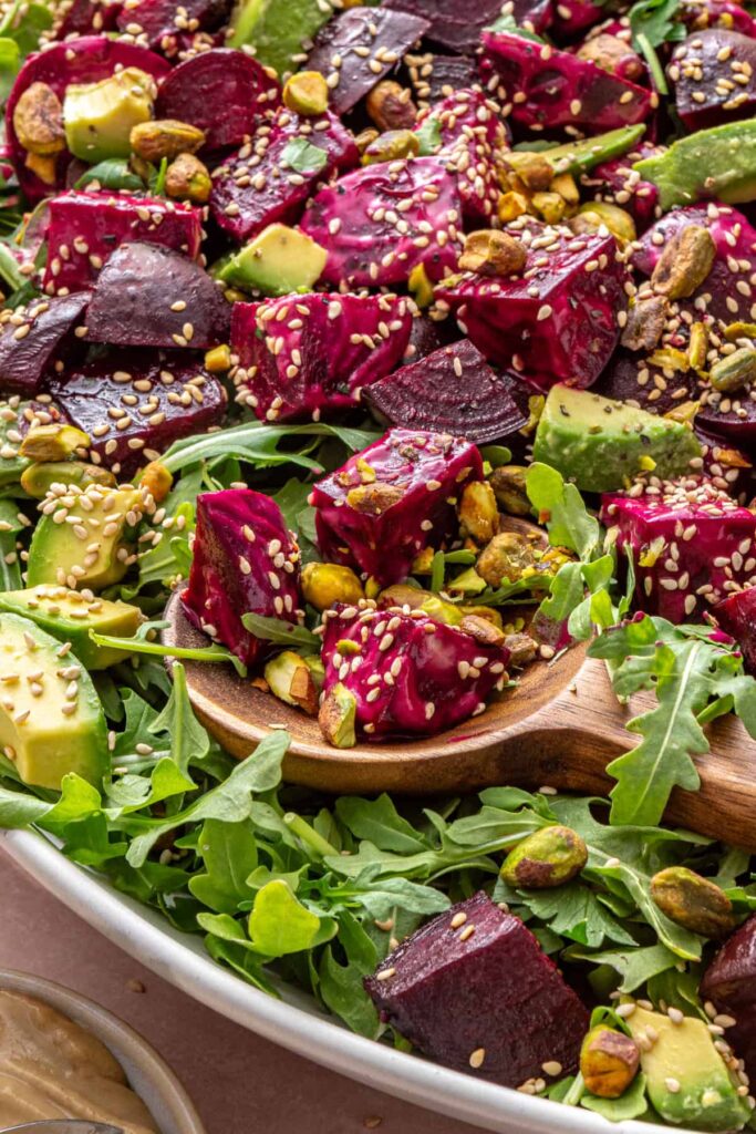 Close-up side angle of roasted beet salad with sesame seeds and pistachios