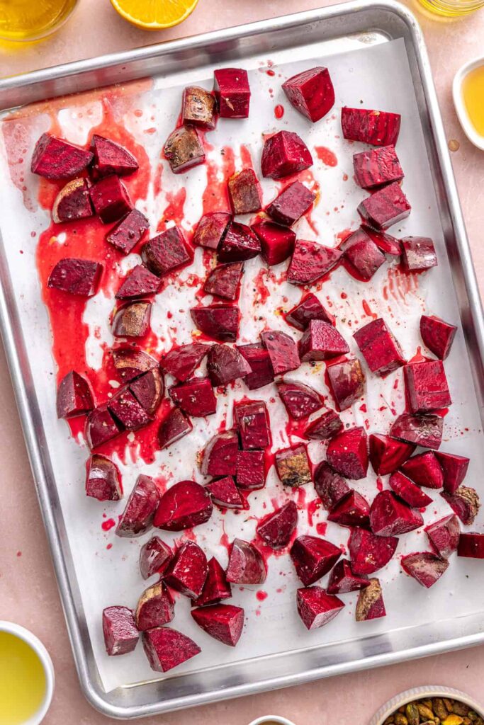 Seasoned beets on a parchment-lined baking sheet before roasting