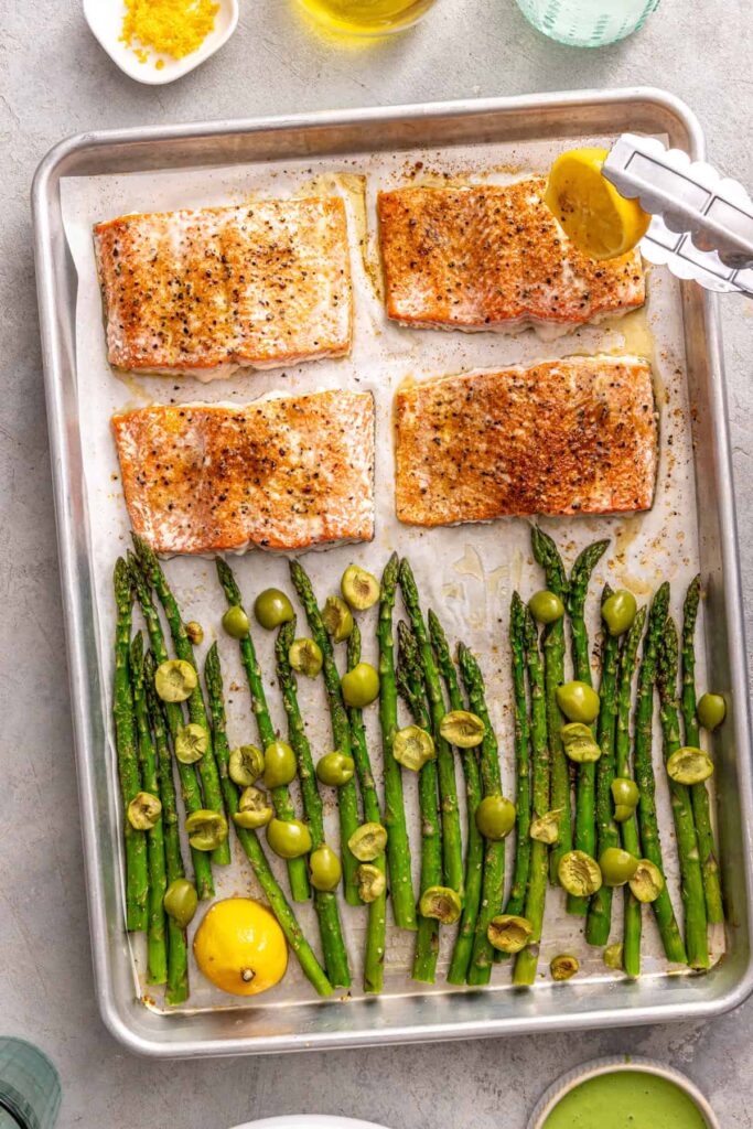 Baked salmon fillets with roasted asparagus, olives, and lemon