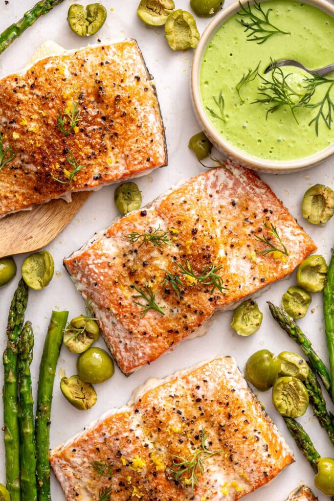 Healthy baked salmon dinner with asparagus and olives
